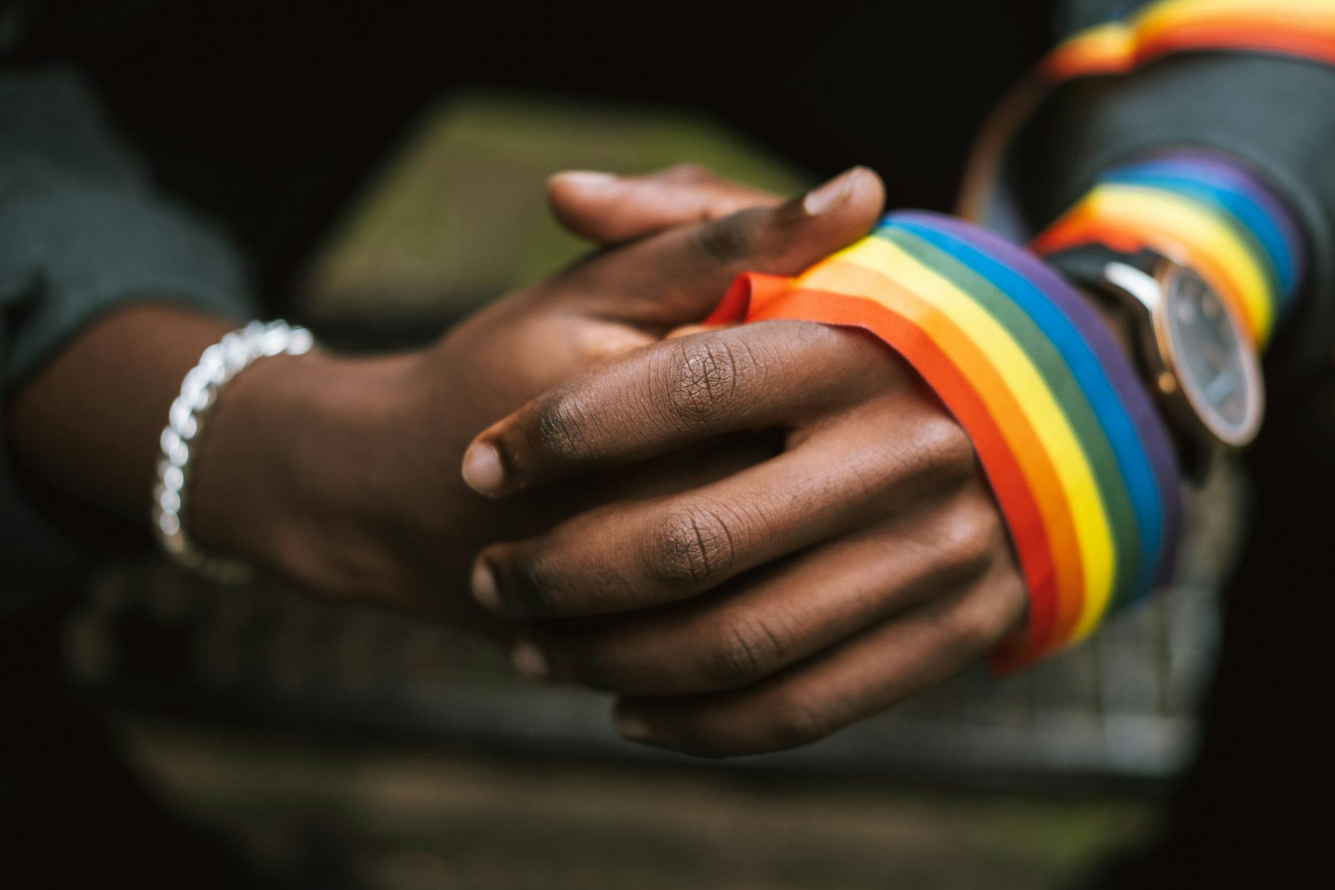 crop unrecognizable black man wearing lgbt ribbon on arm